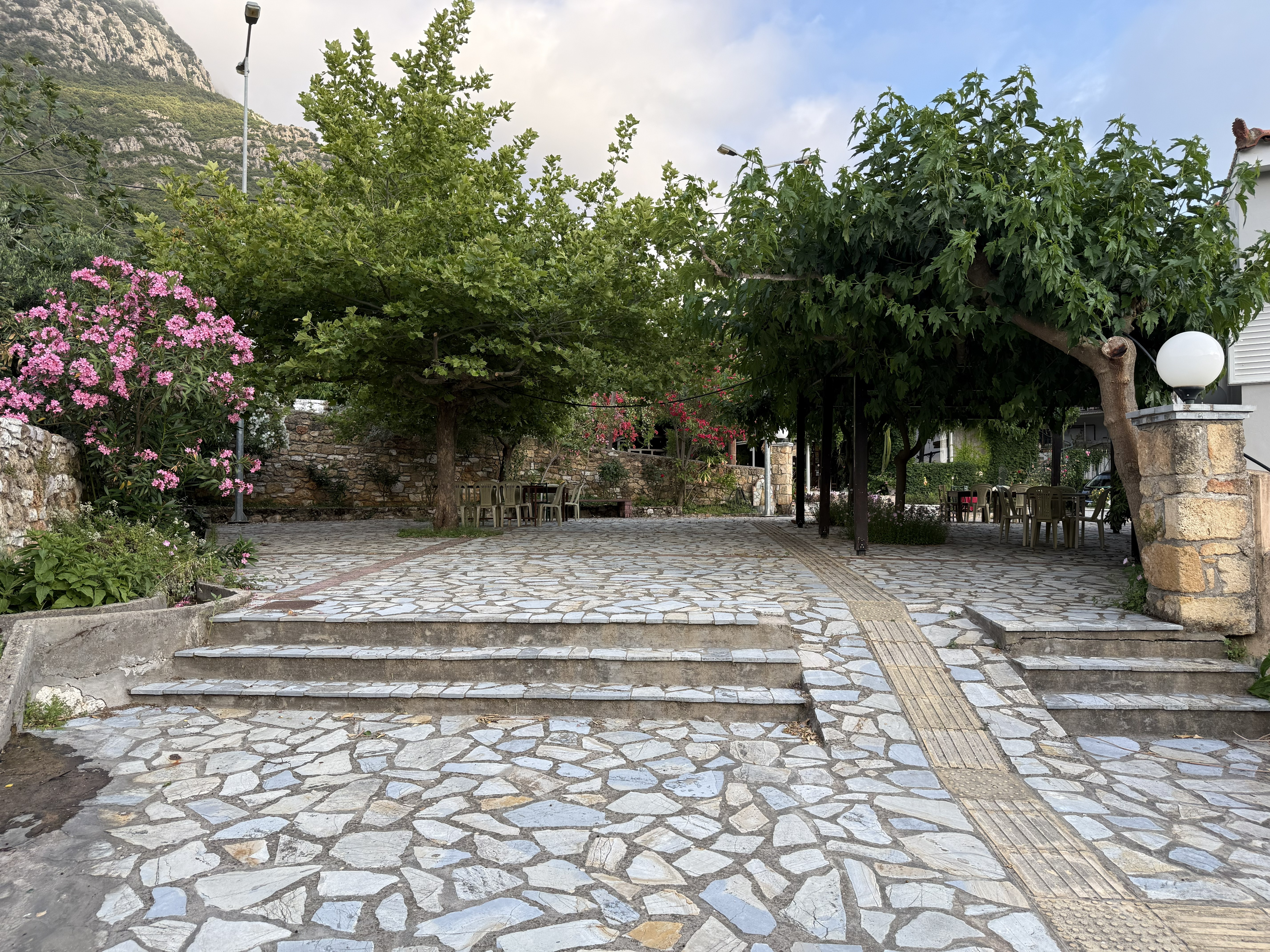 Κεντρική πλατεία Περδικονερίου — πλακόστρωτο με πέργκολα και πέτρινες κλίμακες
